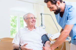 Nurse helps senior man with blood pressure measurement