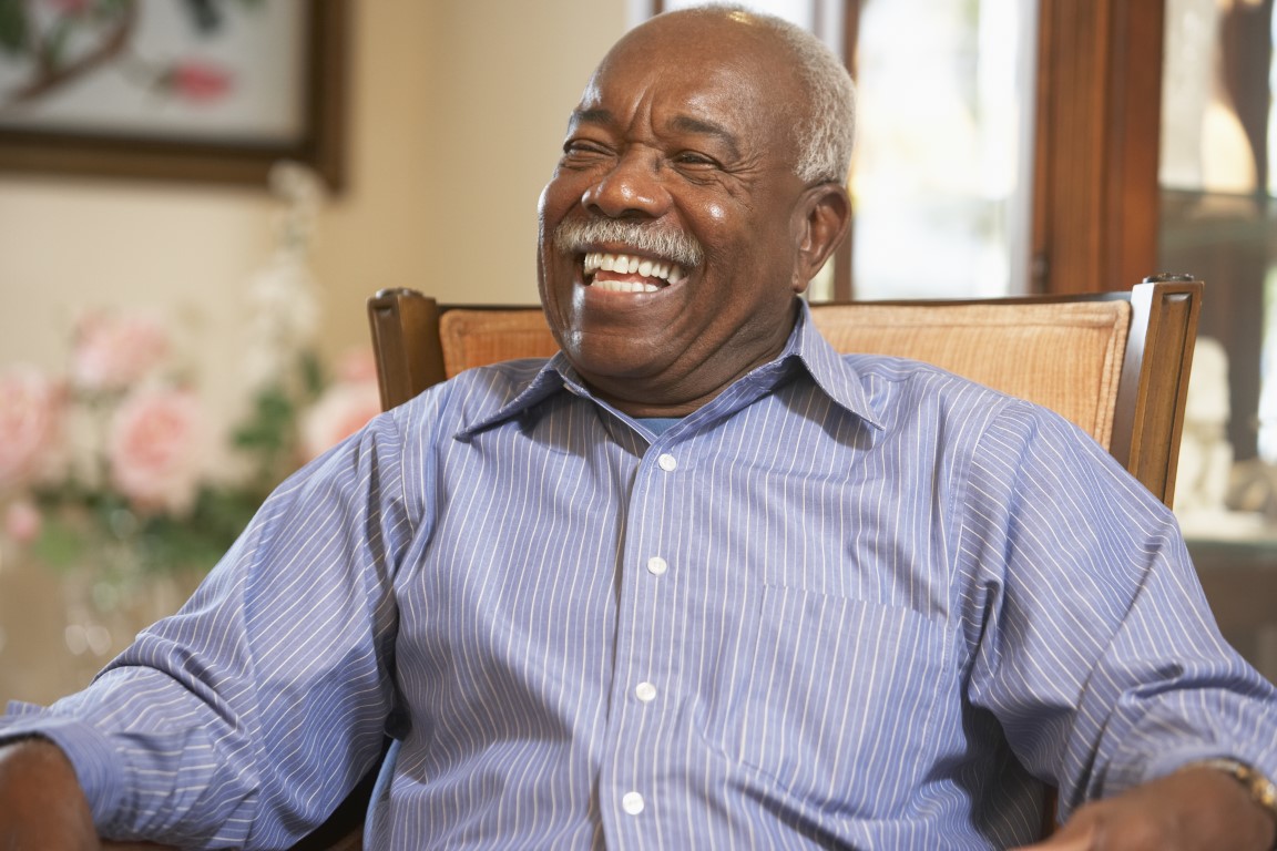 Senior man relaxing in armchair and laughing
